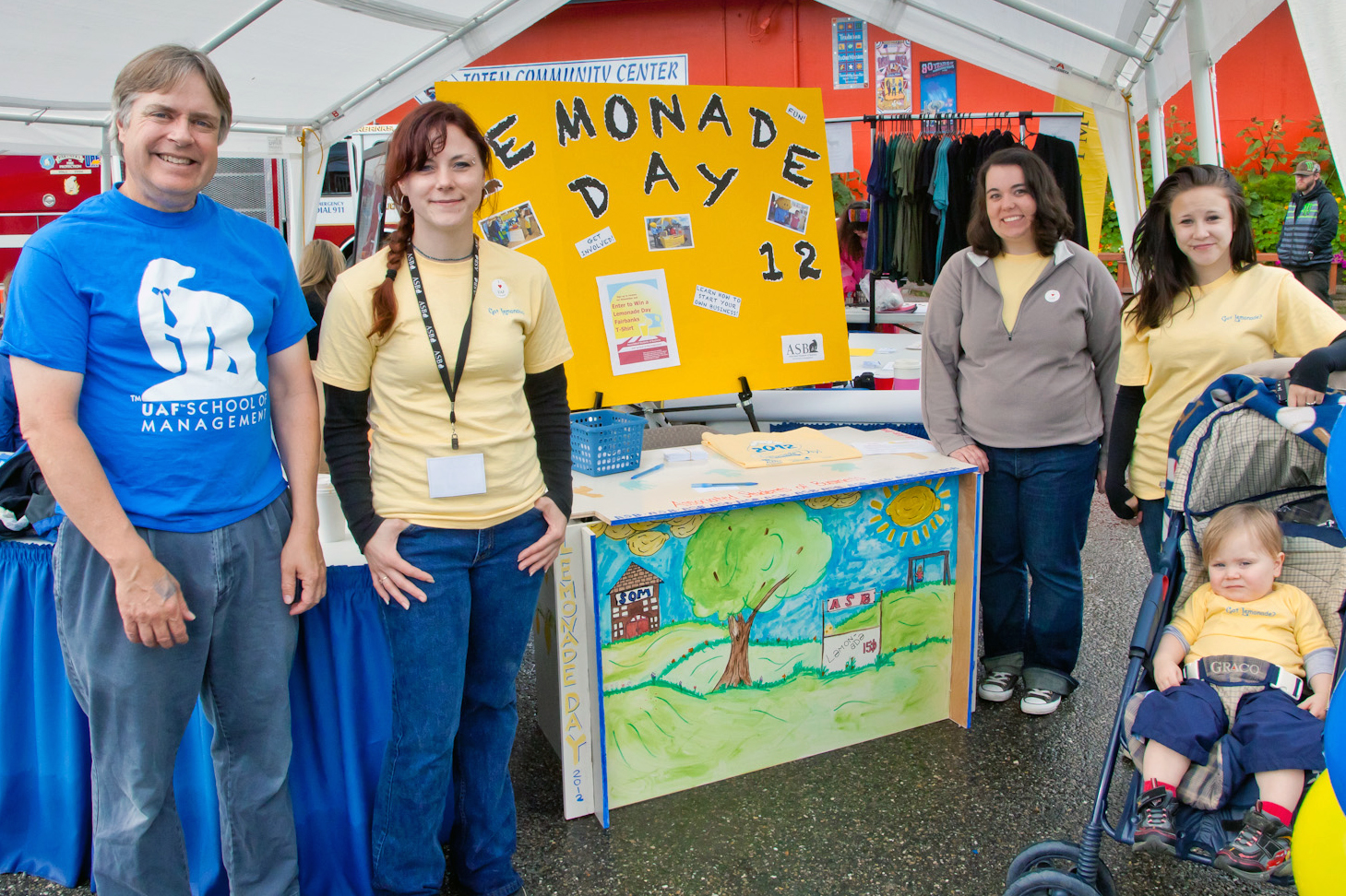SOM Dean Herrmann (left) visits the ASB Lemonade Day Alaska booth at the 2011 Tanana Valley State Fair.