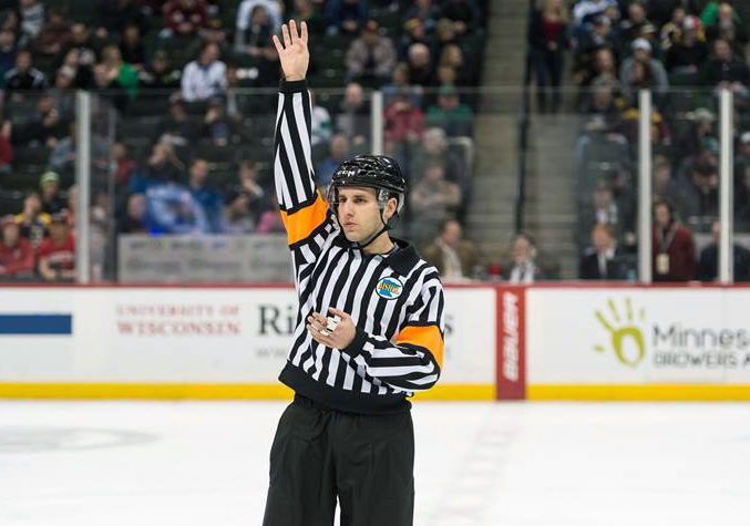 Josh refereeing at a hockey game.
