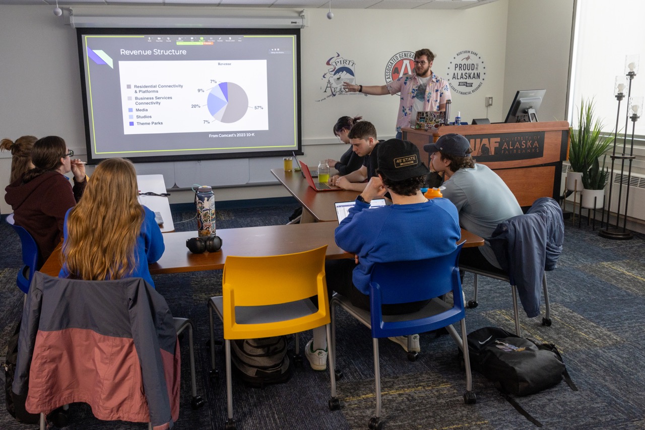 student gives presentation with a piechart of stock information