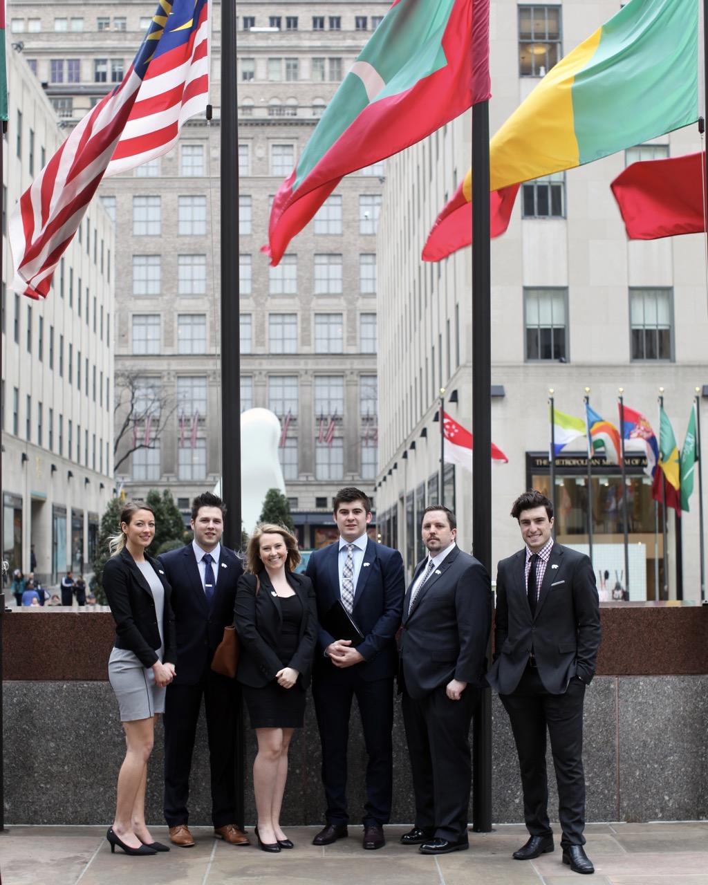 six students pose together in professional clothing in the city