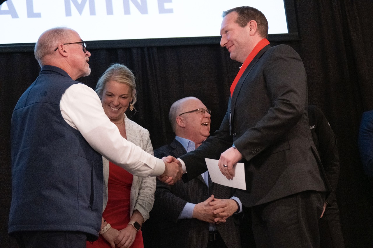 Tim Illguth, right, shakes hands with Dean Cameron Carlson as he accepts his $6,000 check and silver medal.