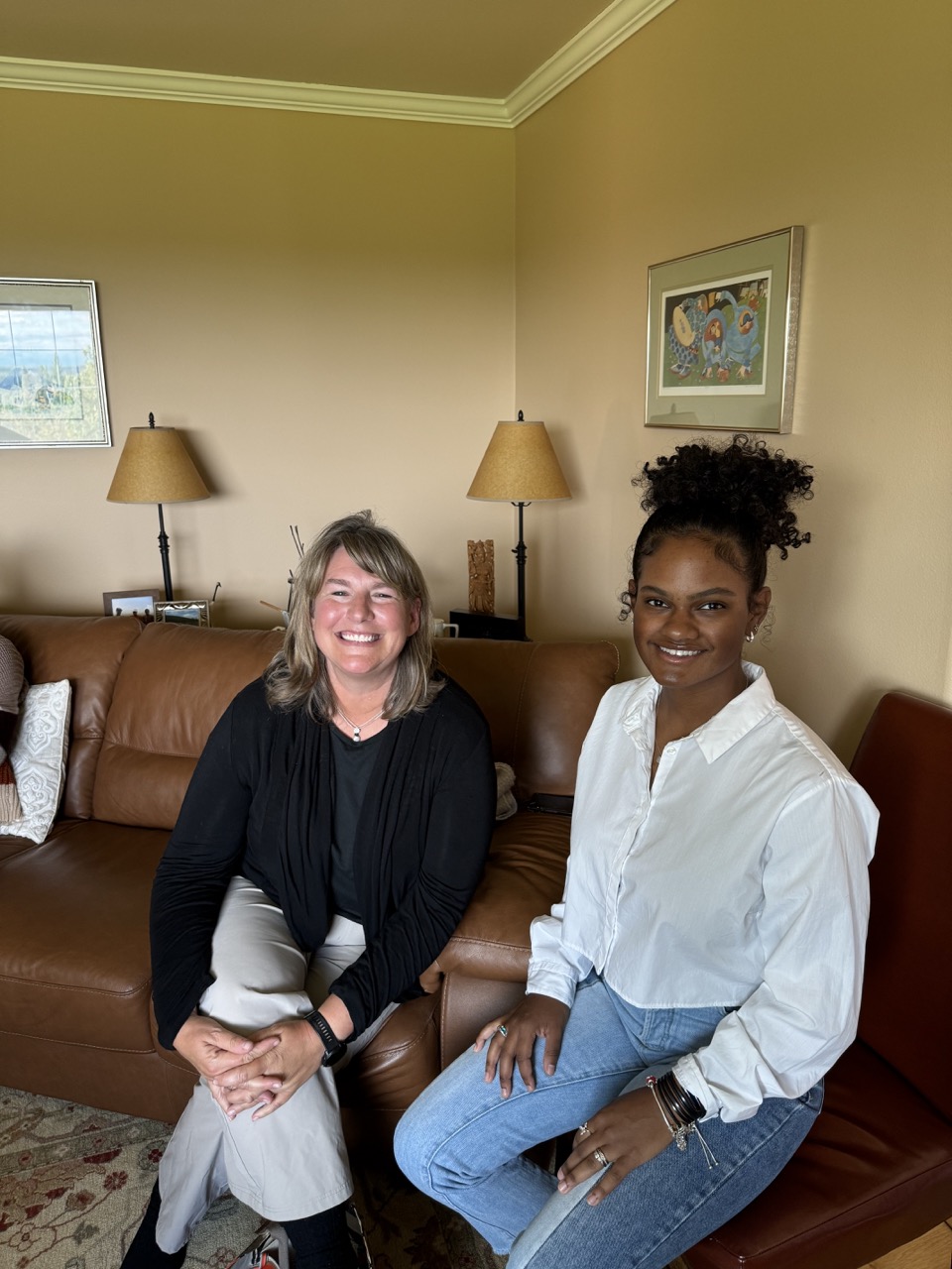 Mentor and student sit on a couch in a living room