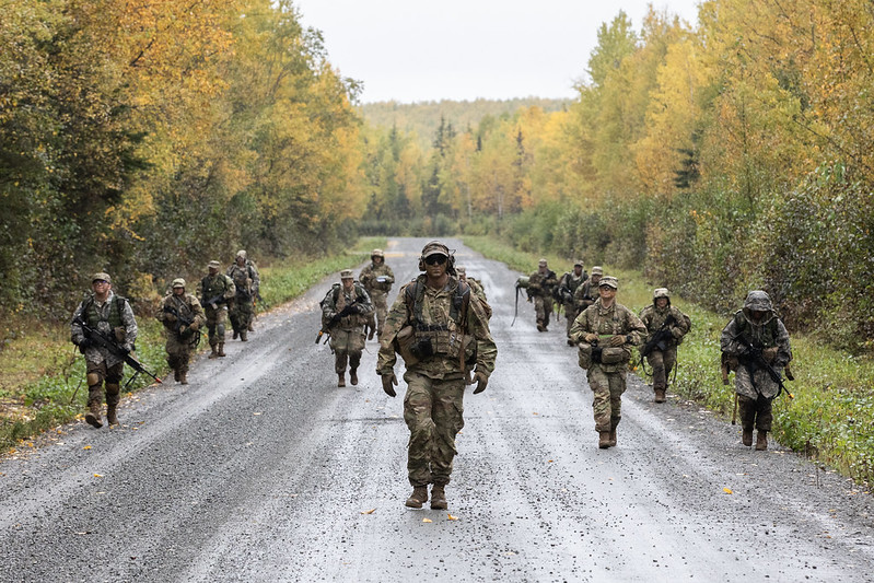 Soldiers march in uniform on a rural street in Alaska