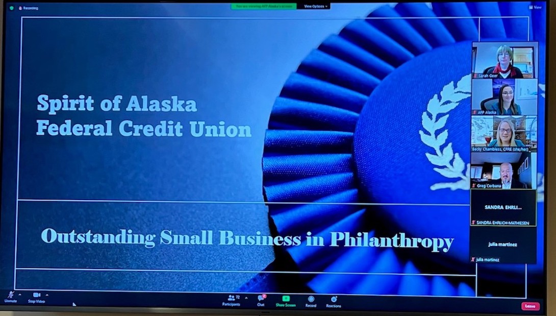 Blue computer screen that reads Spirit of Alaska Federal Credit Union - Outstanding Small Business in Philanthropy with six online participants on the right side