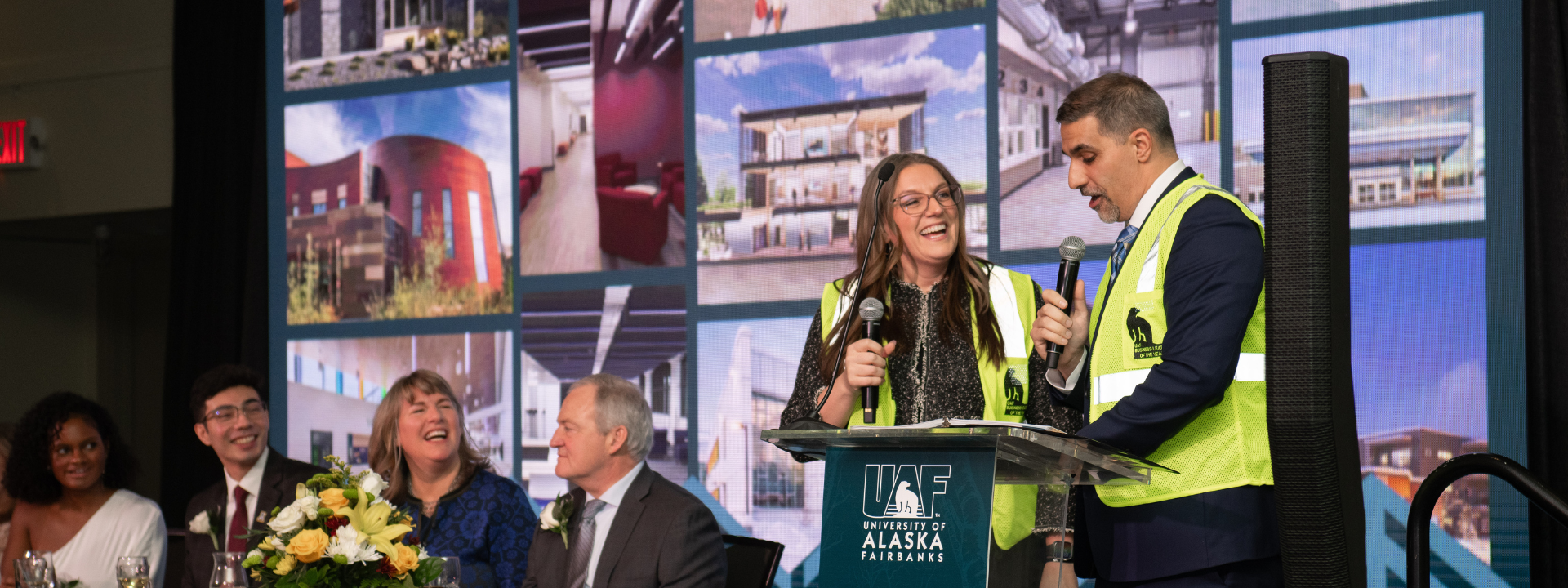 speakers laugh together on stage at event