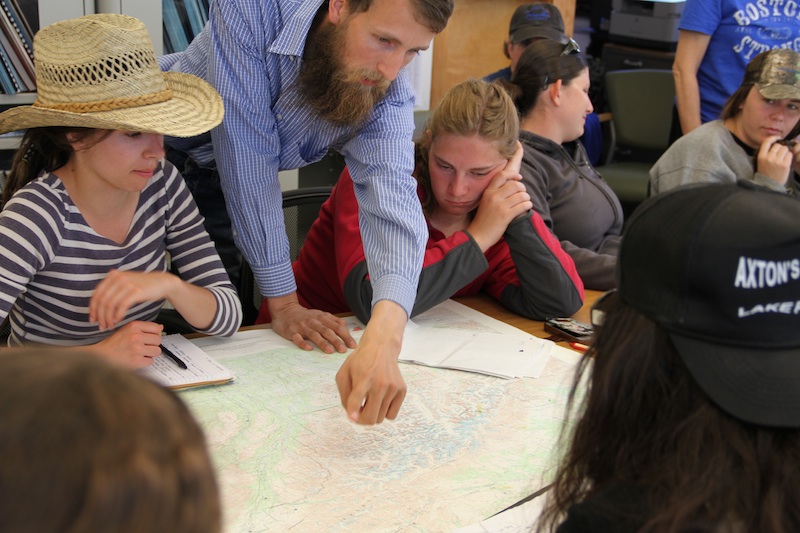 David Betchkal, Denali National Park physical science technician, pores over a map with students during his presentation about noise in wilderness settings.