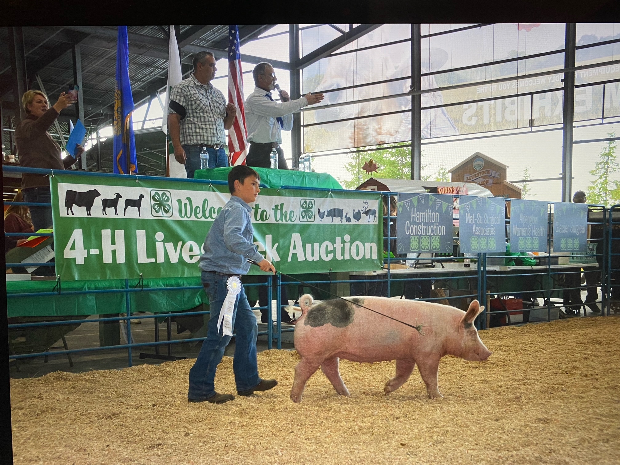 Student standing beside swine