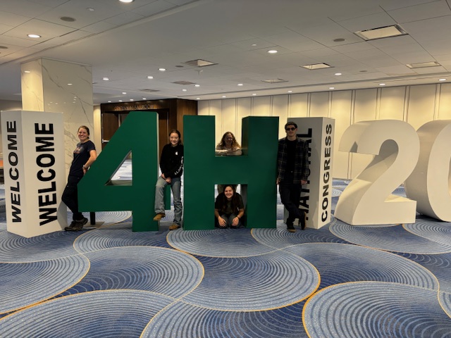 Students holding large 4-H letters