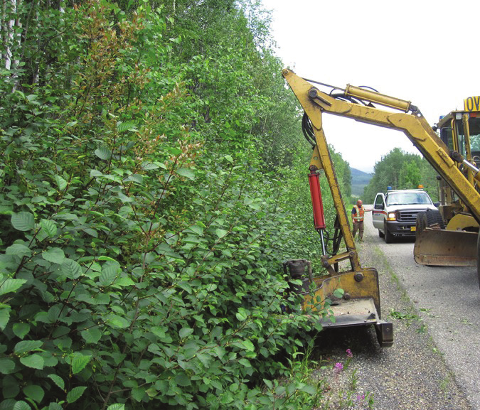 A yellow and black construction vehicle is parked on the roadside