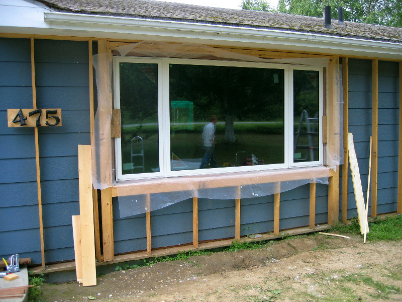 A house retrofit showing both the exterior wall being framed in