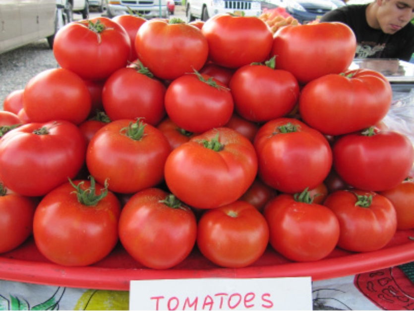 Shelf with three stacks of round, red vegetables