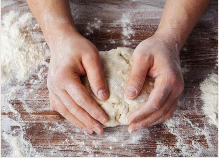 Kneading floured dough on a cutting board