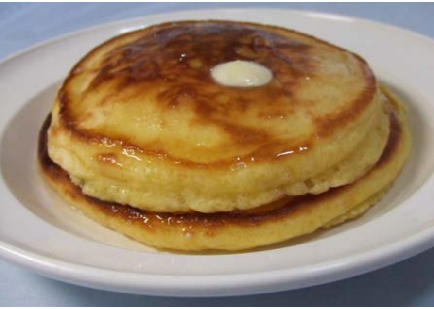 A stack of flat golden brown pastries with butter on top