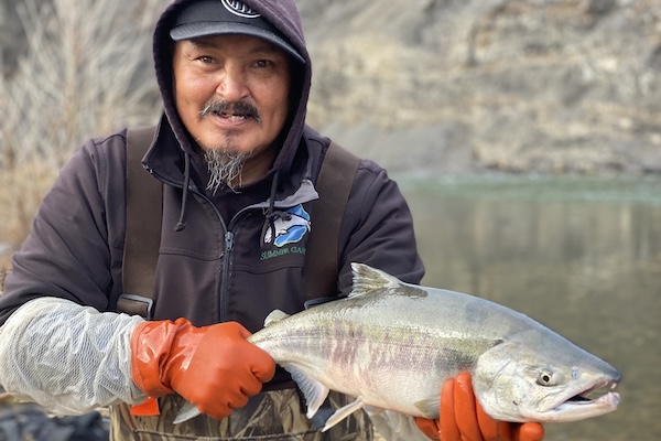 Frankie Dillon displays a chum salmon caught in the Big Fish River, near Aklavik, Northwest Territories, in 2023. Photo: Colin Gallagher, DFO.