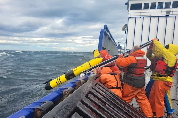 Scientists aboard the patrol vessel Stimson launch the glider Shackleton off the side of the ship to search for tagged juvenile crabs in Bristol Bay.