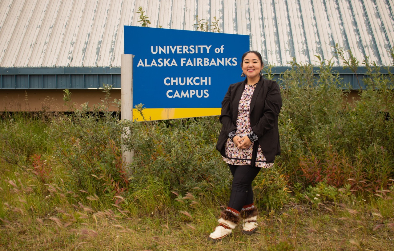 Minnie Naylor standing in front of Chukchi sign