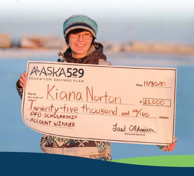 Young girl wearing glasses and a knit hat poses with a giant check.