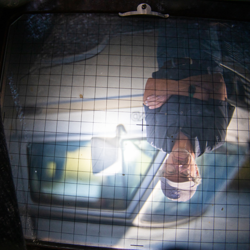 Charles Mason poses with his VW Syncro Westfalia Vanagon as seen through the viewfinder of his 8X10 camera at Creamer's Field Wednesday, August 17, 2022. UAF Photo by Eric Engman