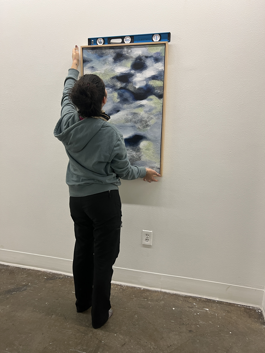 Ayona-Reily Dixon hanging a painting in the UAF Art Gallery. Photos courtesy of Bitzer & Dixon.