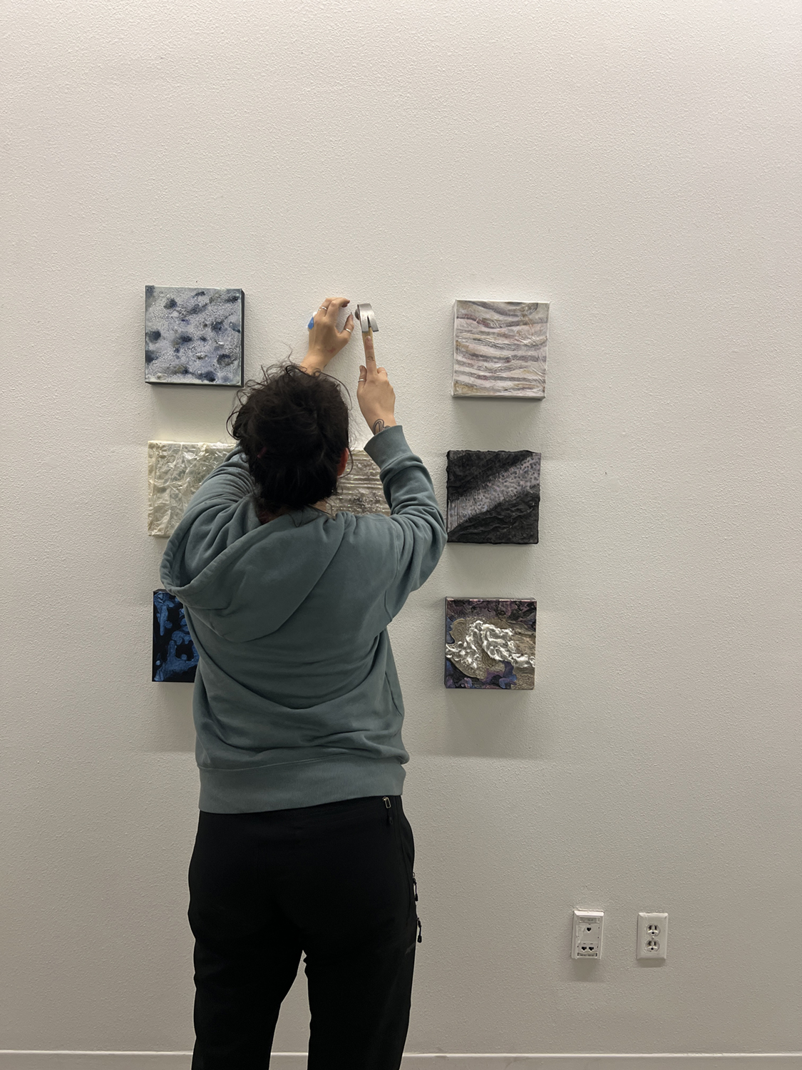 Ayona-Reily Dixon hangs paintings in the UAF Art Gallery. Photos courtesy of Bitzer & Dixon