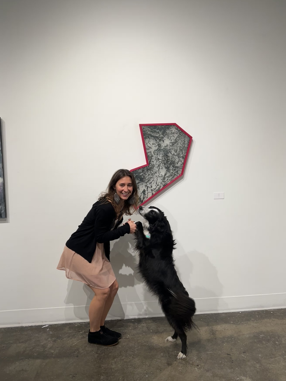 Sasha Bitzer poses with a dog in front of a piece of artwork in the UAF Art Gallery. Photos courtesy of Bitzer & Dixon.