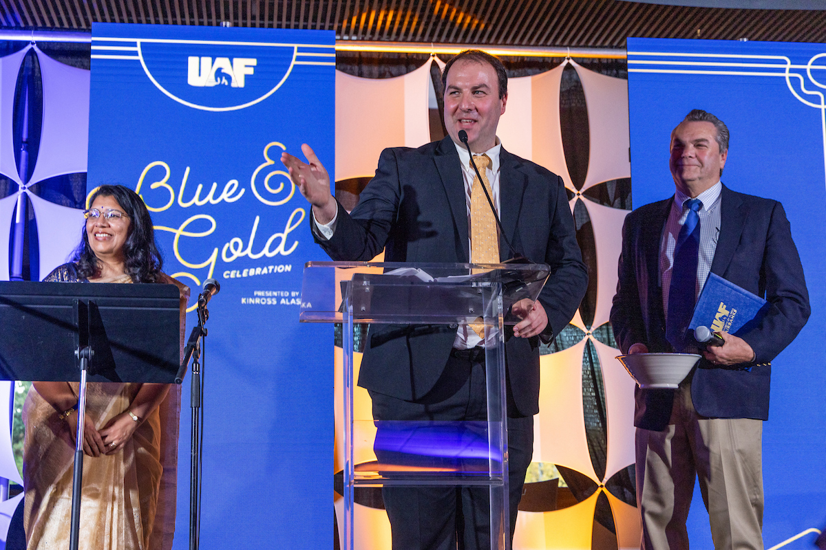 Brandon Boylan, political science professor and director of the Arctic and Northern studies program in the College of Liberal Arts, received the Emil Usibelli Distinguished Teaching Award at the Blue & Gold Banquet and Fundraising Auction at Dine 49 on the UAF campus Saturday, September 14, 2024. Provost and Executive Vice Chancellor Anupma Prakash, left, and Joe Usibelli Jr., right. UAF Photo by Eric Engman