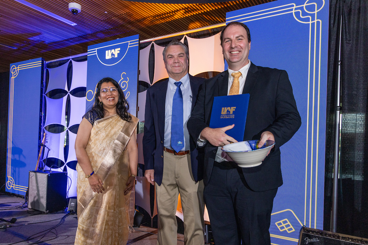 Brandon Boylan, political science professor and director of the Arctic and Northern studies program in the College of Liberal Arts, received the Emil Usibelli Distinguished Teaching Award at the Blue & Gold Banquet and Fundraising Auction at Dine 49 on the UAF campus Saturday, September 14, 2024. Provost and Executive Vice Chancellor Anupma Prakash, left, and Joe Usibelli Jr., center.