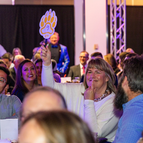 Tracy Vanairsdale, president of Bettisworth North Architects and Planners Inc. and a member of the chancellor's Board of Advisors, holds up her bidder's paddle at the Blue & Gold Banquet and Fundraising Auction at Dine 49 on the UAF campus Saturday, September 14, 2024.