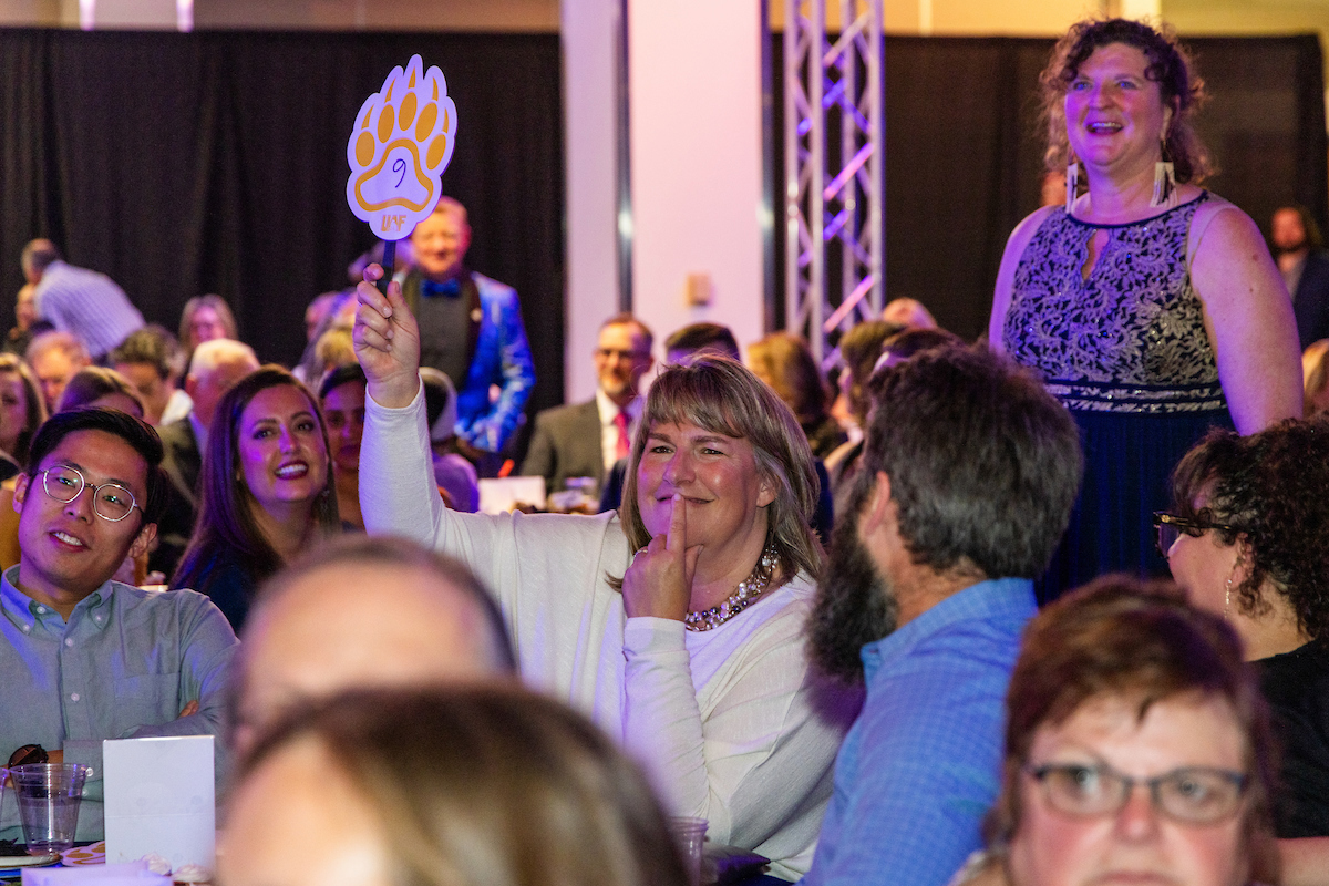 Tracy Vanairsdale, president of Bettisworth North Architects and Planners Inc. and a member of the chancellor's Board of Advisors, holds up her bidder's paddle at the Blue & Gold Banquet and Fundraising Auction at Dine 49 on the UAF campus Saturday, September 14, 2024. UAF Photo by Eric Engman