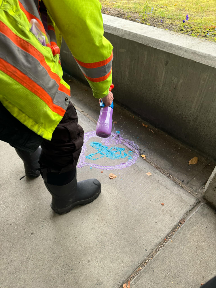 A student stencils a positive message on a concrete walkway of the UAF campus. UAF Photo by Jamie Haman