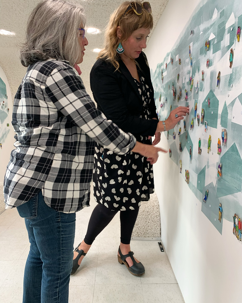 Somer Hahm adjusting the magnetic cats in her Cat Town exhibition. Photo courtesy of Somer Hahm