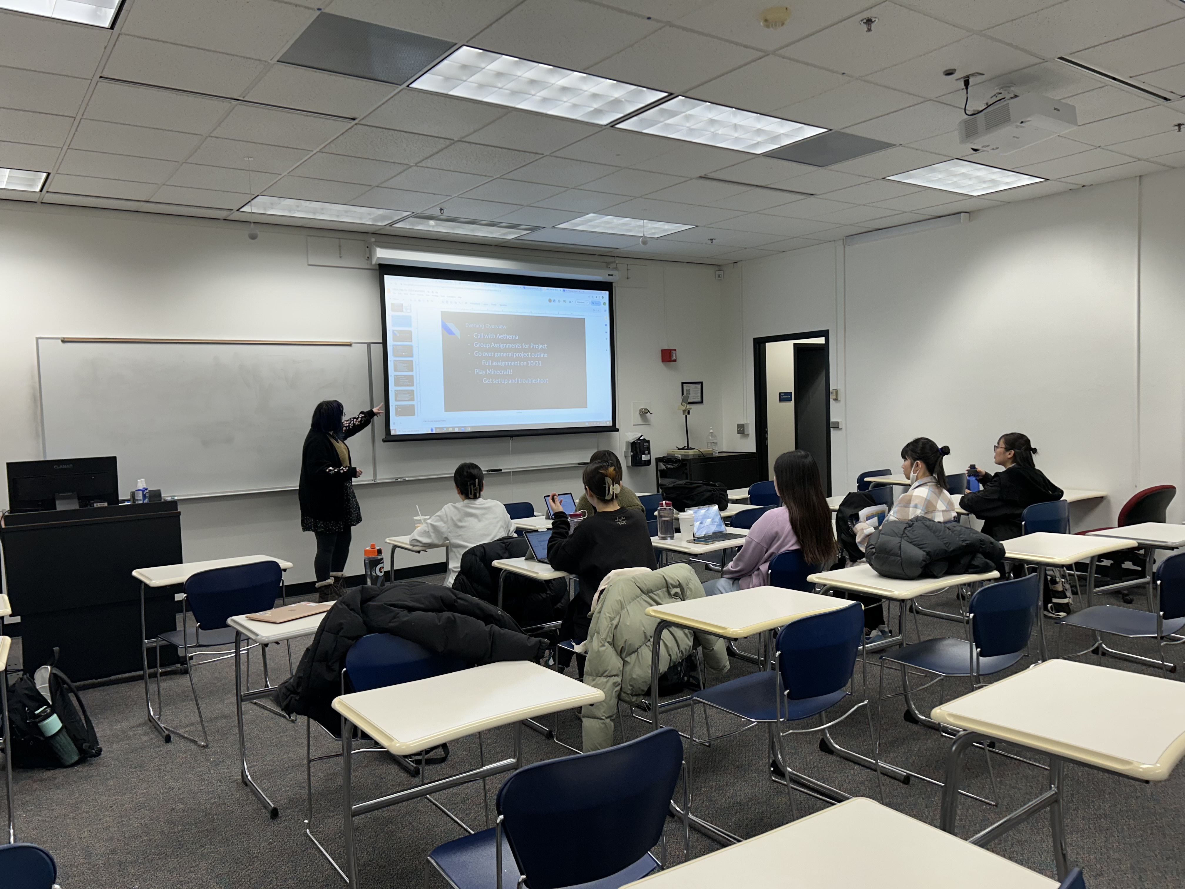 Wetherleigh leading ESL students registered in a conversation class through an evening lesson plan. Photograph from URSA website.