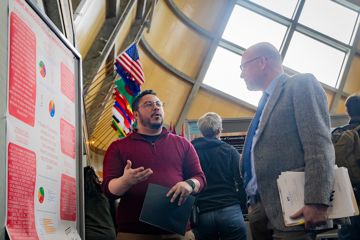 Charles Stark presents their RCA poster on Student Belonging through Program Orientation. UAF Photo by Leif Van Cise.