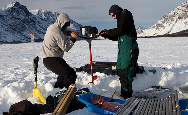 two researchers using an auger.