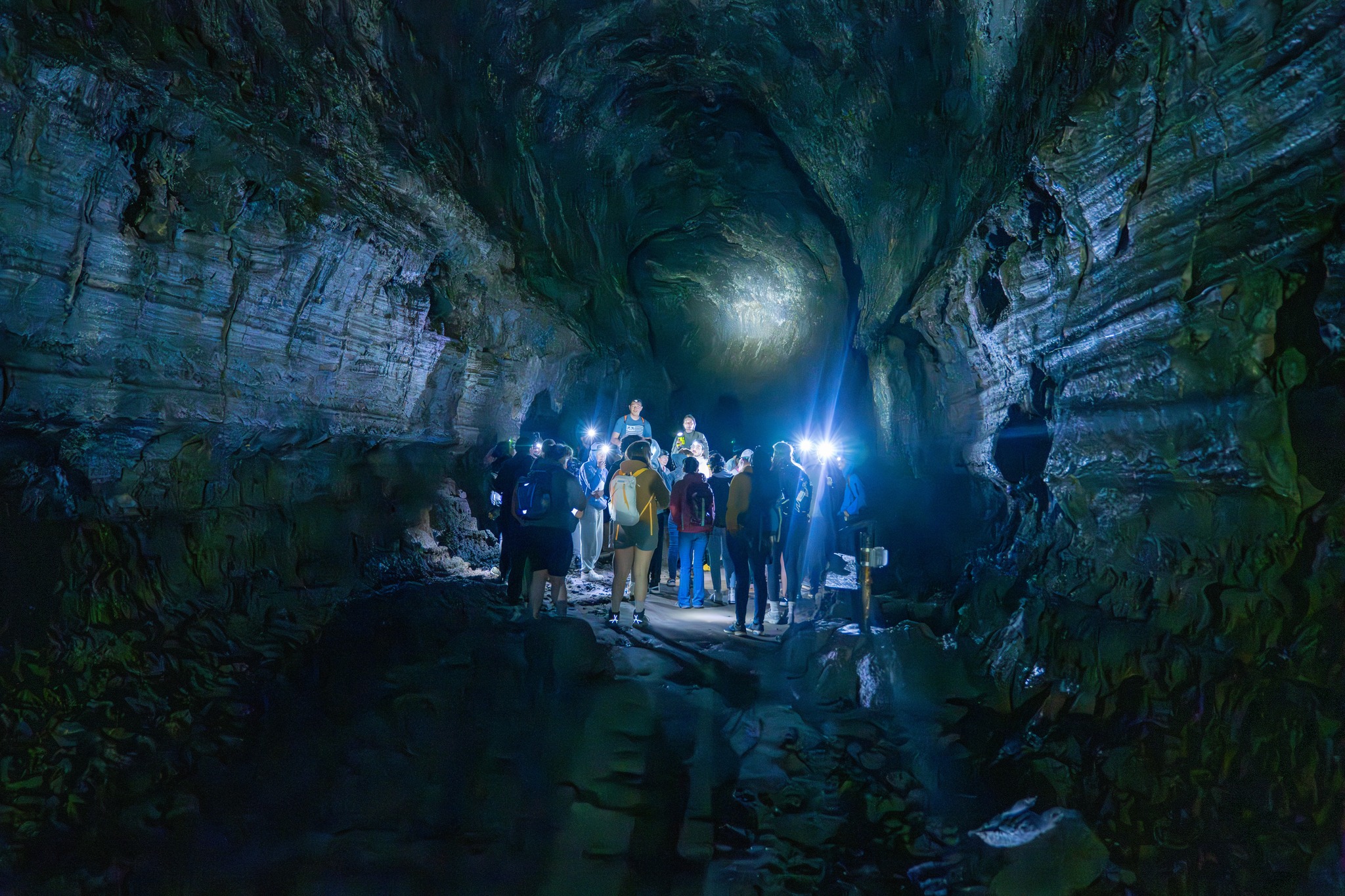students in a dark cave with headlamps