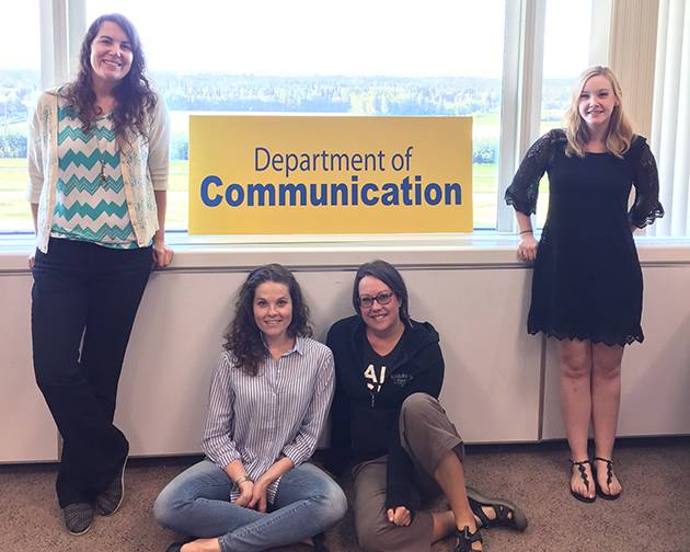 Communication Graduate Students pose for a quick photo on campus.