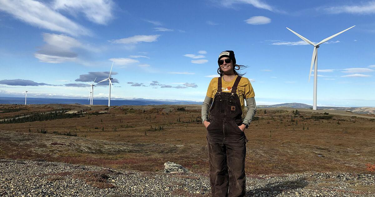 Julia poses with windmills and a blue sky in the background