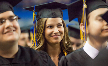 Student in graduation cap, smiling.