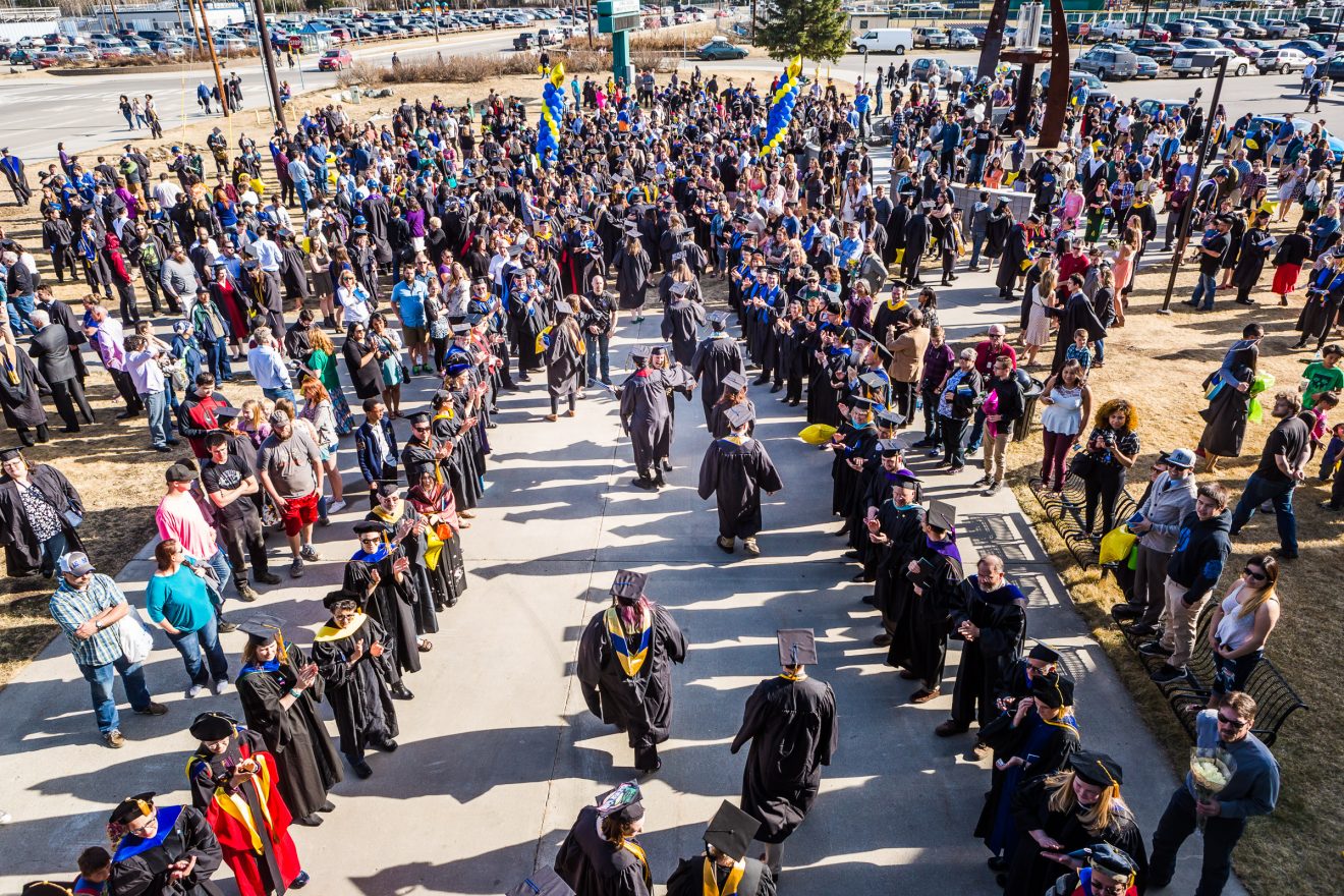 Forming two lines outside the Carlson Center, faculty greet and congratulate graduates after the Commencement 2017 ceremony on May 6 in Fairbanks. UAF photo by JR Ancheta.
