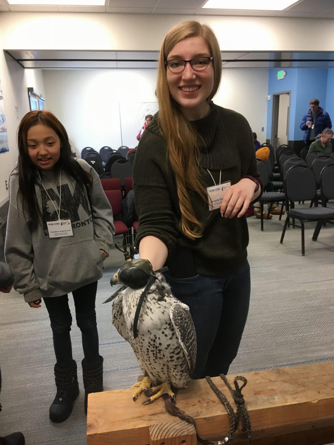 Creedence Ongtowasruk (left), a seventh-grader from Wales, and Janelle Trowbridge, a UAA student, with Tinsel the gyrfalcon.