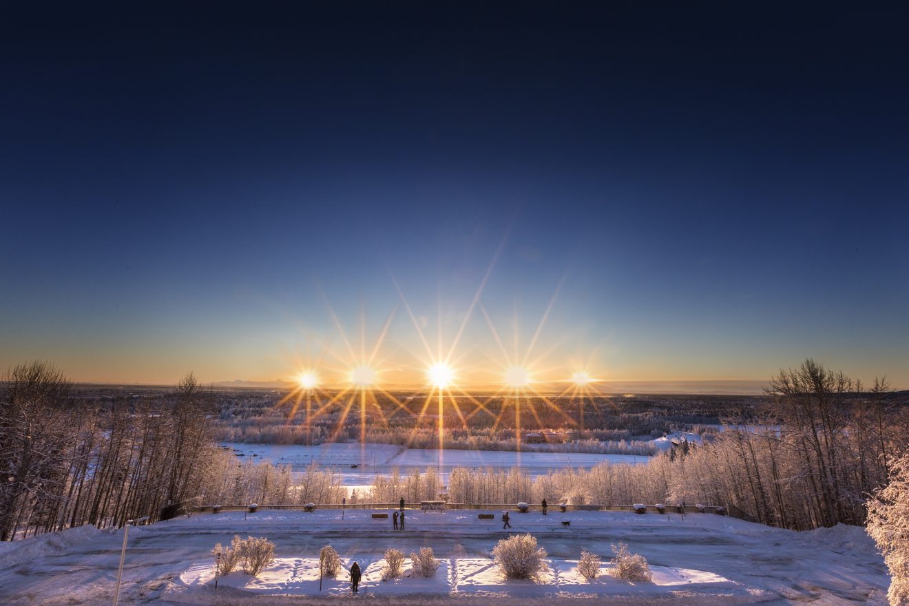 The sun rises and sets above the Alaska Range south of Fairbanks in this composite image taken from the roof of the Reichardt Building on Dec. 21, the day of the winter solstice.