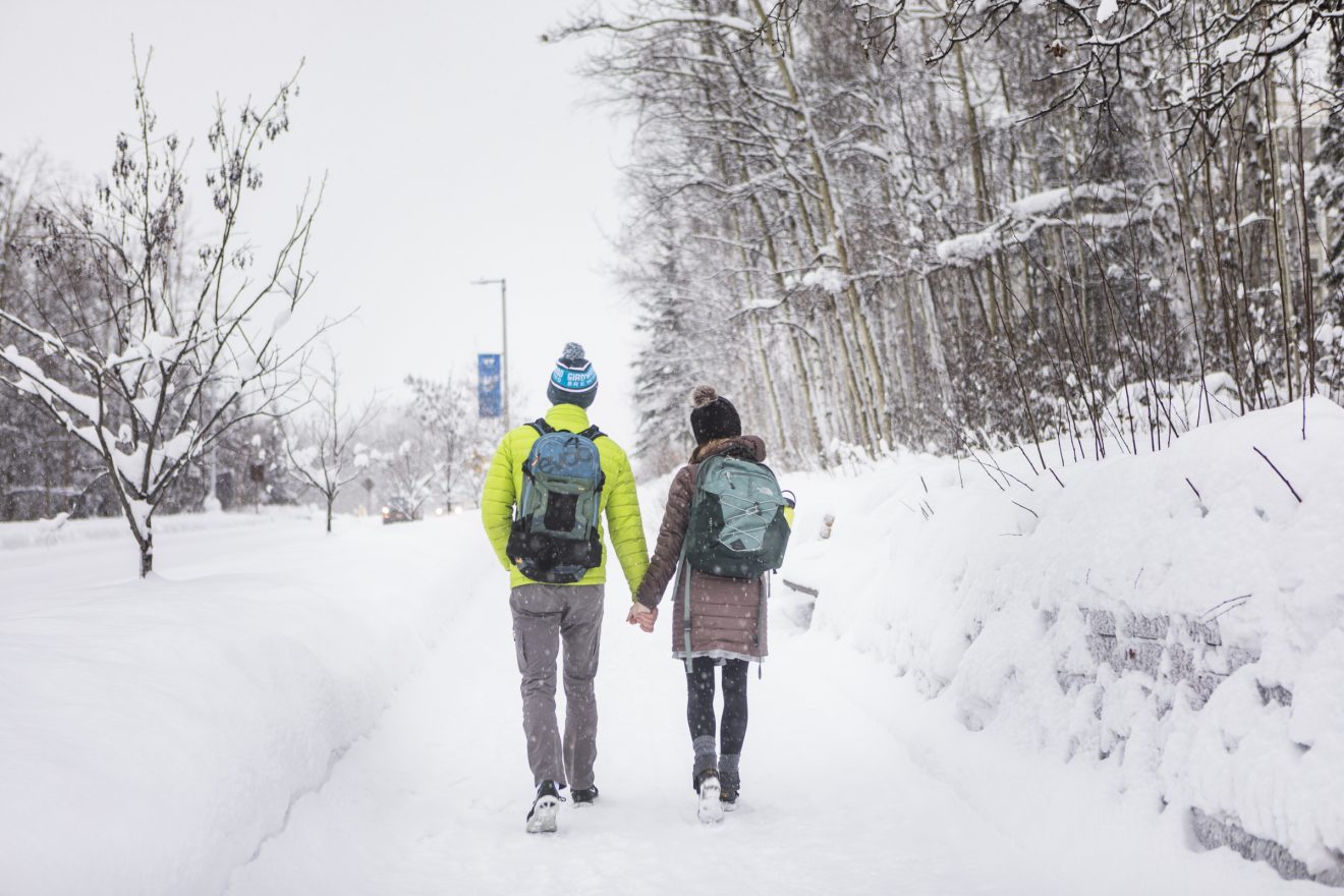 A couple walks toward upper campus on Yukon Drive during a snowy, Valentines Day afternoon at the Fairbanks campus.