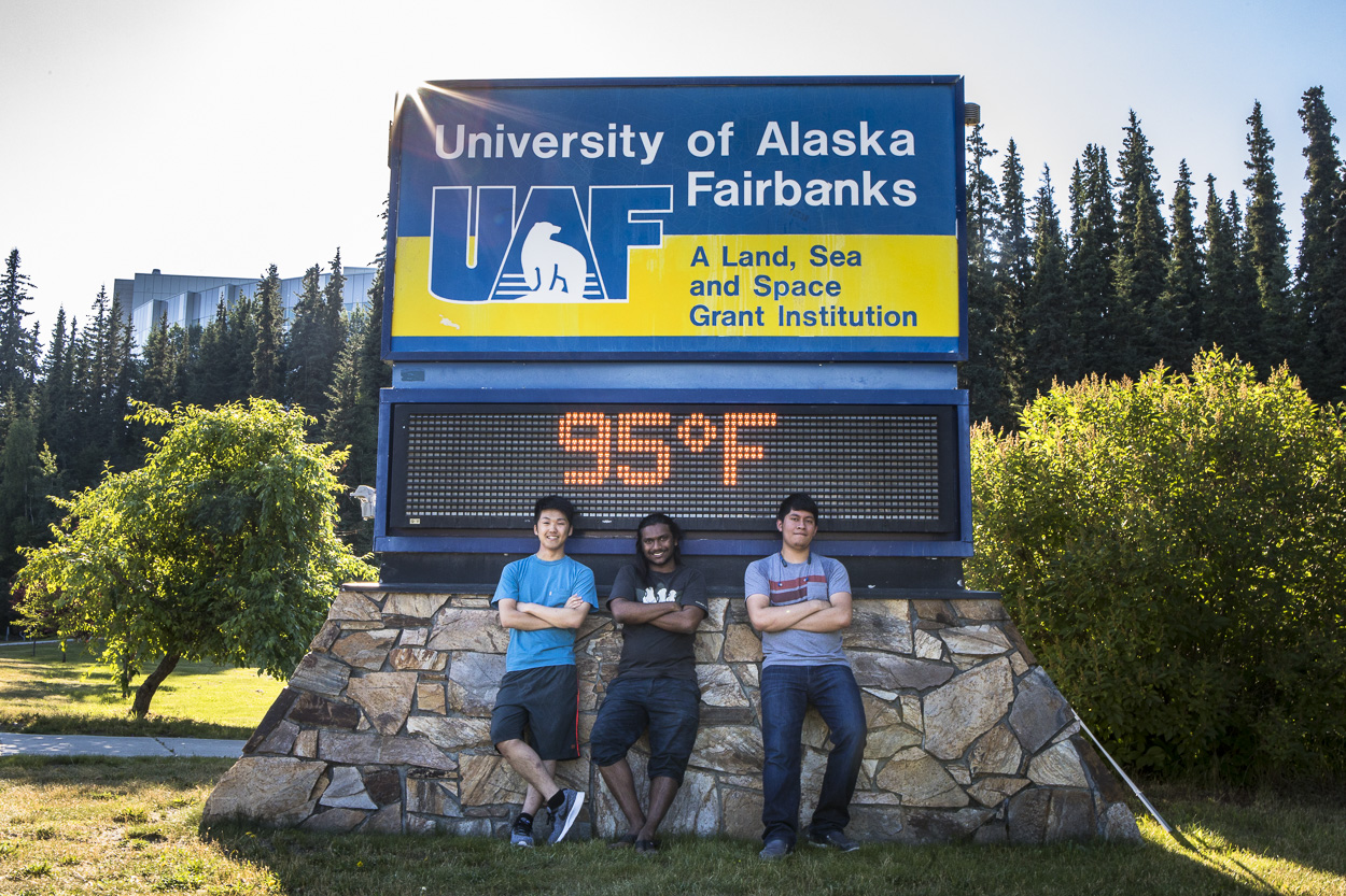 The time and temperature sign at the Fairbanks campus reached 95 degrees Fahrenheit Sunday, July 22, 2018 as Daiki Yamamura, Gabriel Thorai Ravindran and Juancruz Montalvo Rivas pause for a photo on their way home from ice cream.