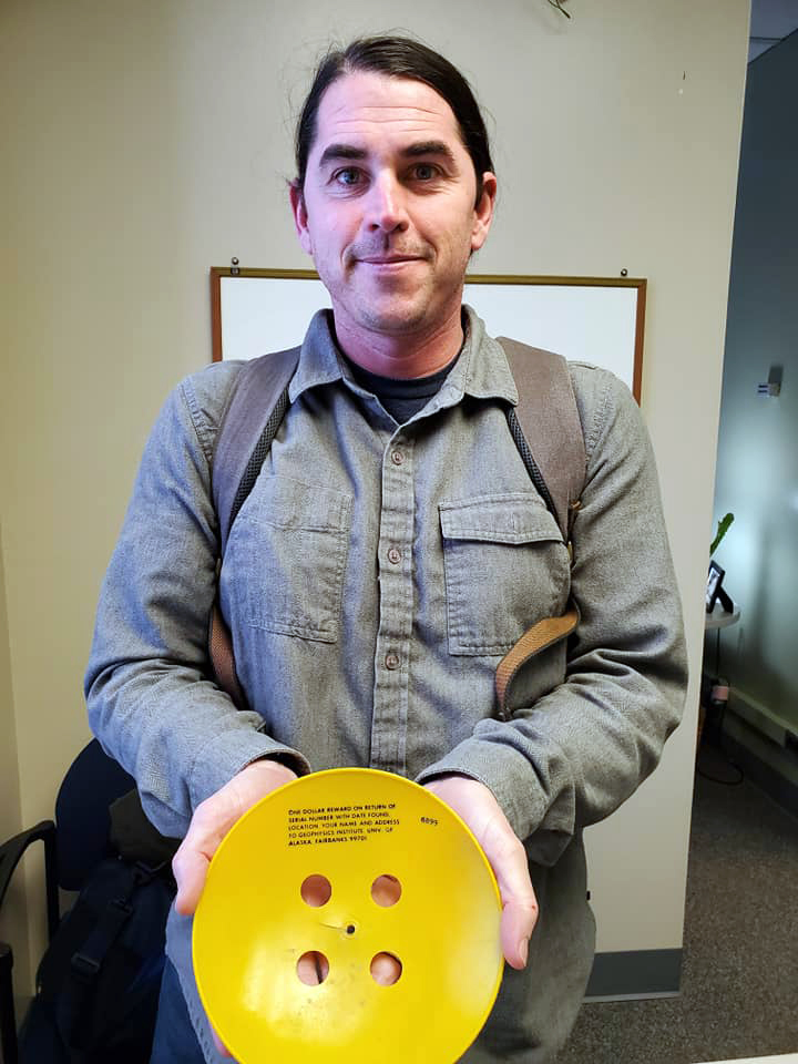 UAF’s Ben Jones with a plastic disc researchers released on northern sea ice 40 summers ago. A pilot working with Jones found it in August 2019, not far from where it was released. Photo by Fritz Freudenberger