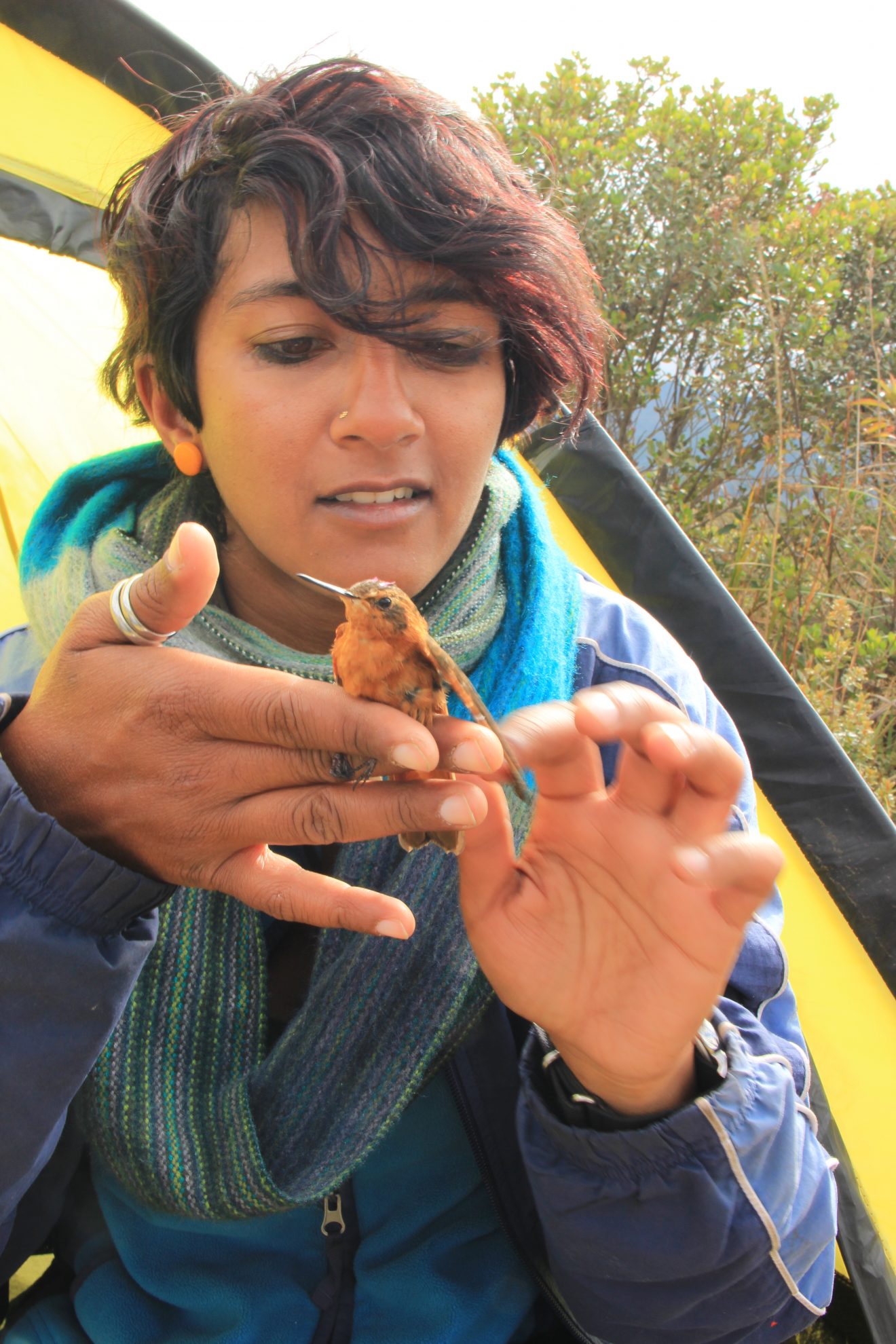 Anusha Shankar holding a small reddish bird.