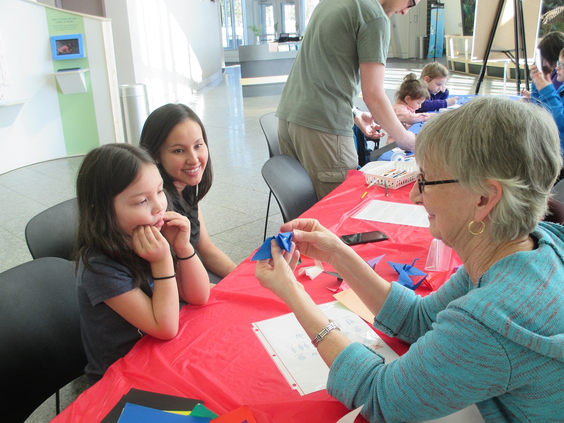A volunteer works with children at an event at the museum.