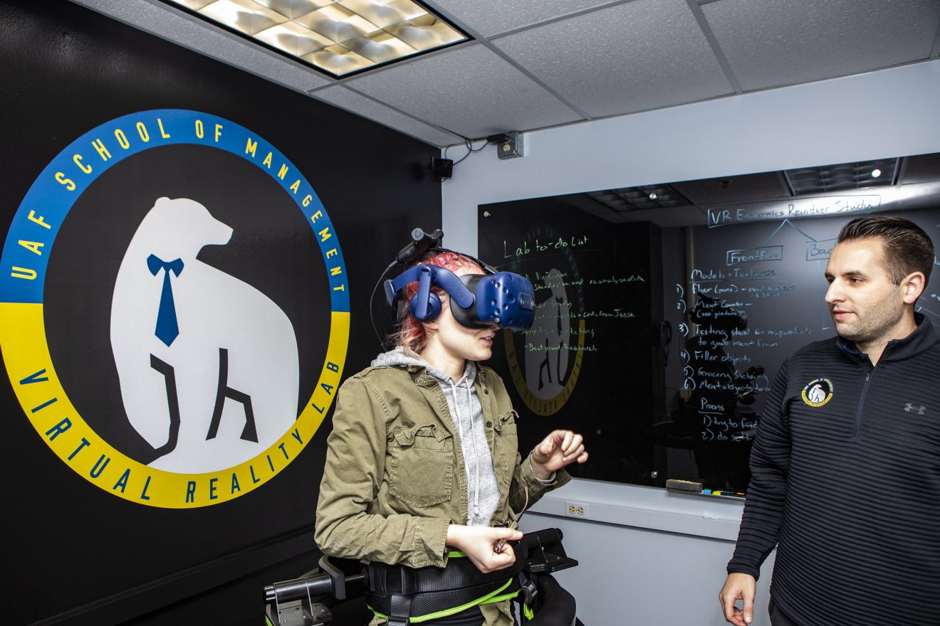 School of Management student Morrow Duszynski tries a virtual reality game at SOM's VR Lab with Assistant Professor Josh Lupinek.