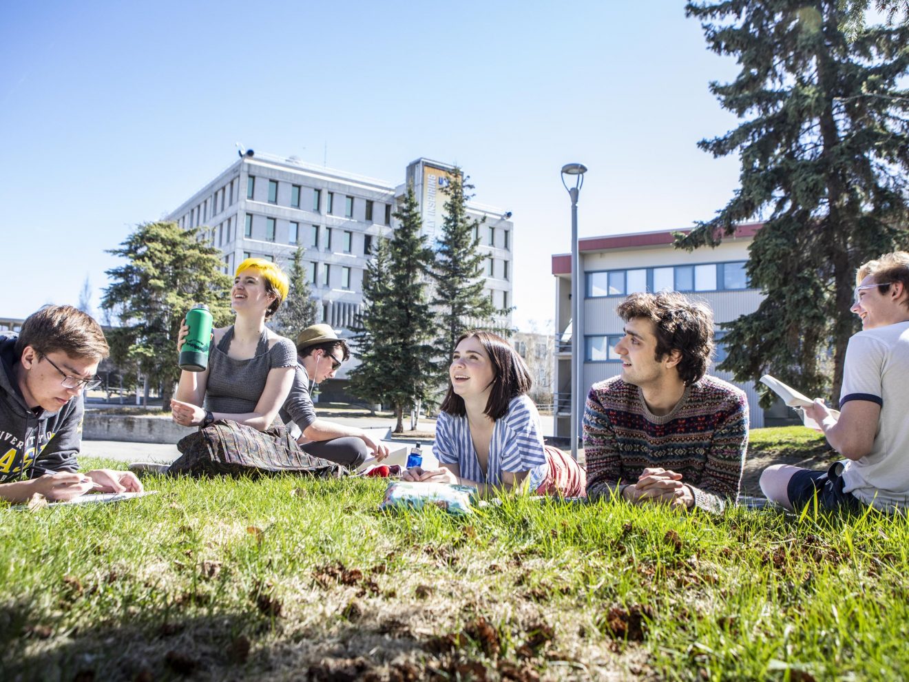 Students enjoy good weather on the green lawn outside Wood Center during finals week on the Fairbanks campus.