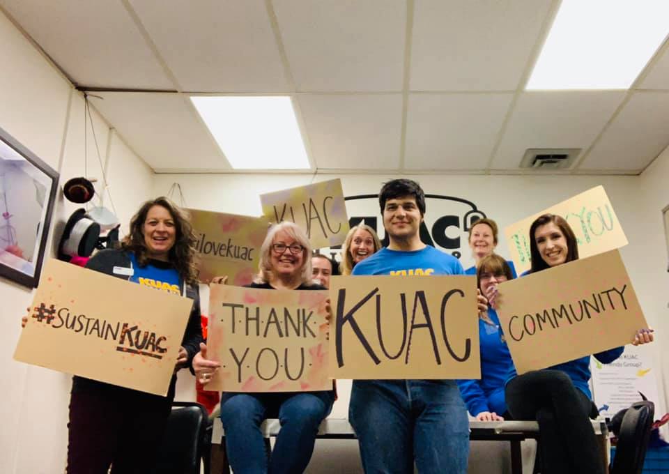 KUAC staff hold up thank-you signs