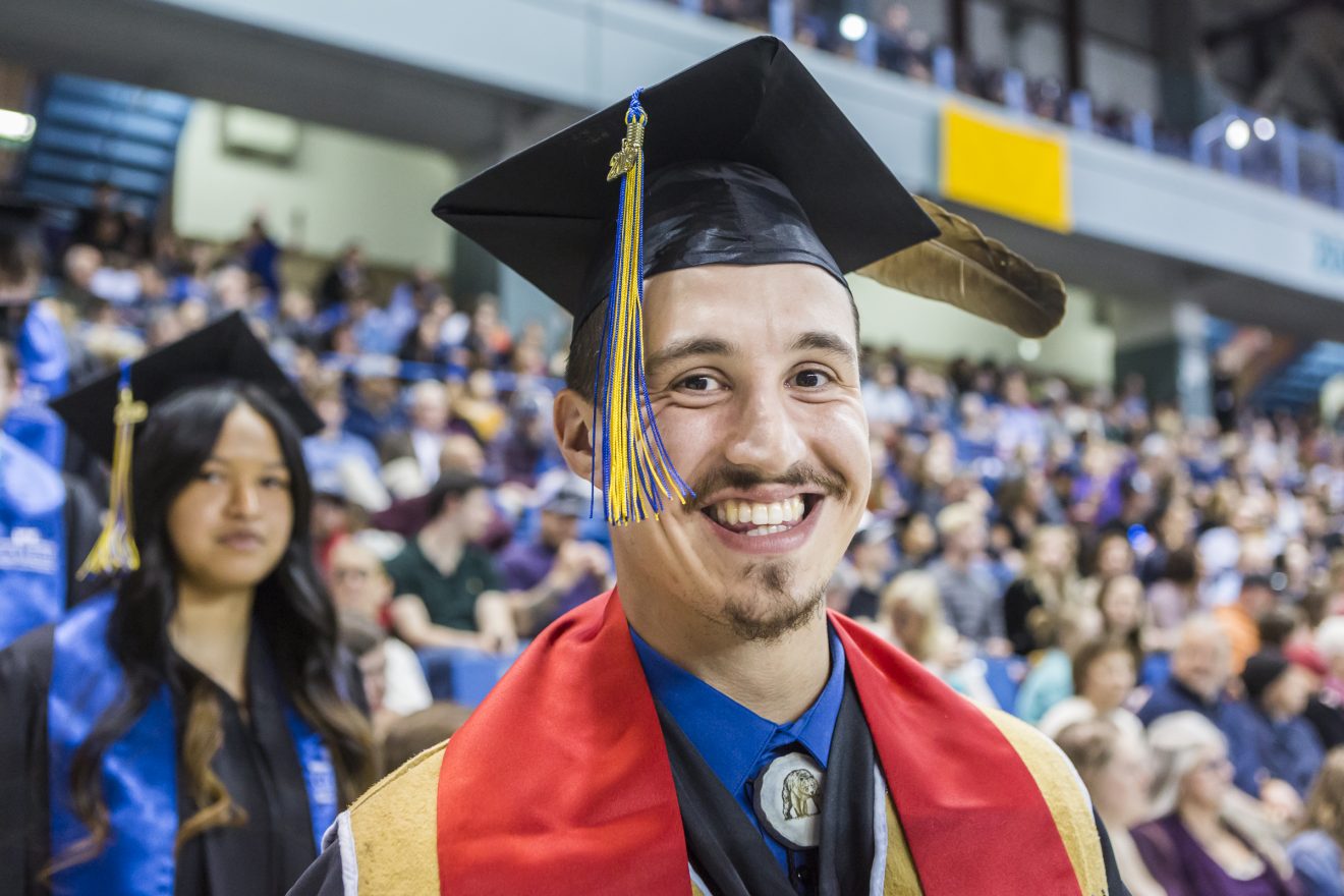 Smiling male Alaska Native graduate at the Commencement 2019 ceremony.